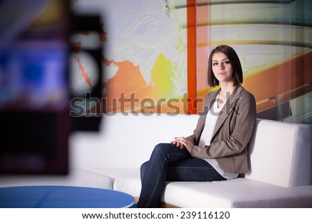 Young beautiful brunette television announcer at studio during live broadcasting.Female TV director at editor in studio.Recording at TV studio with television anchorwoman. TV NEWS studio with camera
