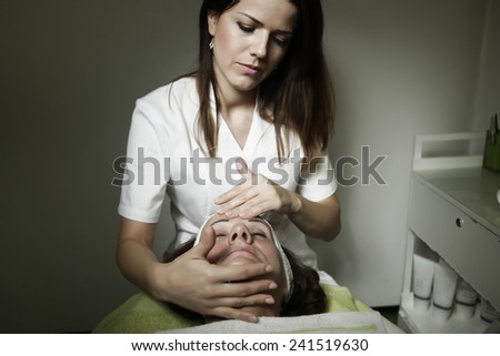 Older woman get facial massage on the spa.Beautiful older woman getting face massage treatment.Senior woman having facial massage