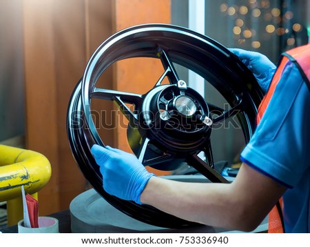 Close up light alloy car wheel in process QC worker checking dish rim. Stock fotó © 