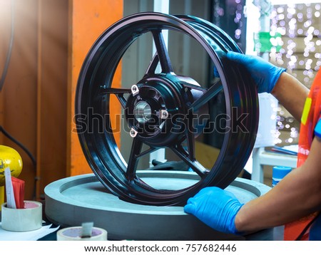 Close up light alloy car wheel in process QC worker checking dish rim. Stock fotó © 