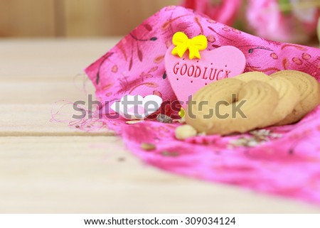 ring cookies on pink table cloth with Good luck word on heart sign