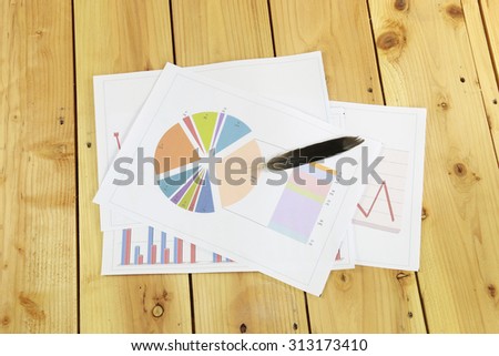 Marketing circle graph and black feather on wood floor