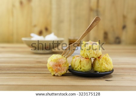 Streamed Chinese Dumpling with black sauce dip ad wood fork