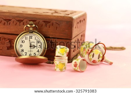 vintage gold pocket watch with old wooden box and mini tea set