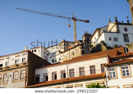 Residential old buildings and building crane rises above them in OPorto, Portugal