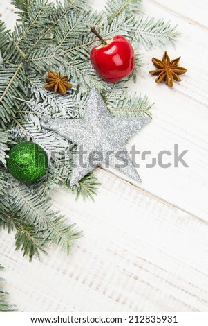 Christmas decoration with fir twigs, baubles, silver star and artificial snow with a blank space