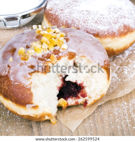 bitten donuts with castor sugar on a wooden table