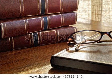 books on the table and glasses and the bottom window and curtains