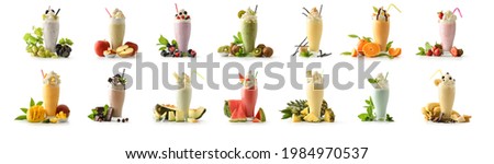 Set of milk shakes with cream in tall glass decorated with fruits of various flavors on white table and white isolated background. Front view.