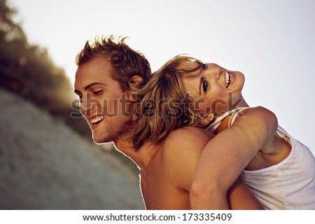 Side view of a cheerful young couple on the beach