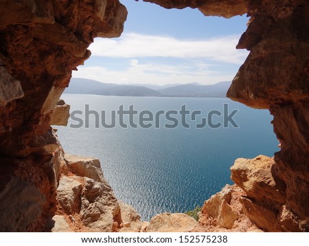 The gap of wonder. Beautiful view through a hole in the medieval walls of the mountaintop Palamidi Fortress in Nafplio, Greece Spring 2013