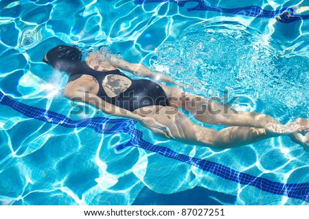 woman with swimsuit swimming on a blue water pool