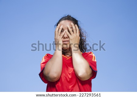 woman with red spanish soccer team shirt scared face