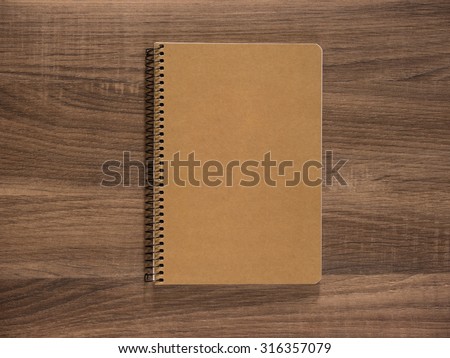 Blank cover of notebook or brochure isolated on wooden table.