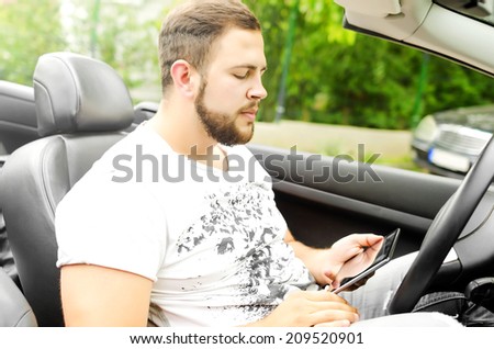 Man in the car with tablet pc