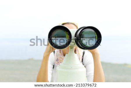 Woman looking through binoculars or telescope