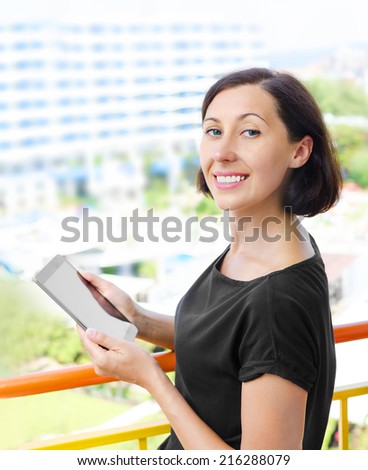 Sweet smiling girl using tablet pc outdoor