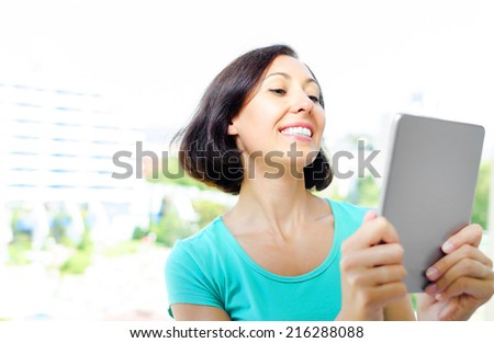 Sweet smiling girl using tablet pc outdoor