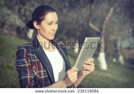 Woman with tablet computer on a background of mountain landscape