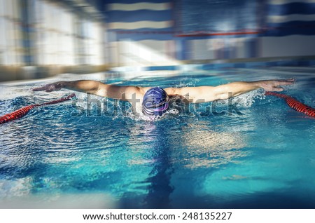 Swimmer training for the butterfly stroke in a swimming pool.