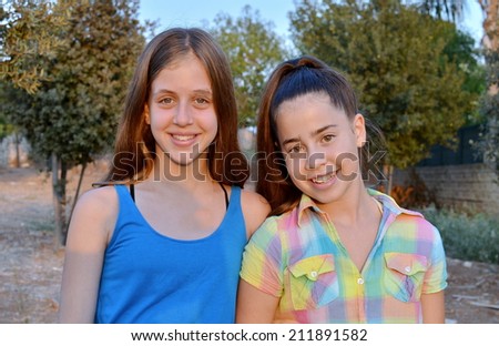 Best Friends Forever - two 12 year old teenage girls  smiling and having fun