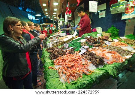 BARCELONA, SPAIN - OCT 14, 2014: People shopping for sea food in the in the famous Barcelona La Boqueria Market (Mercat de Sant Josep de la Boqueria) in Catalonia, Spain