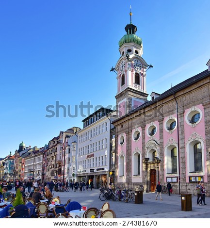 INNSBRUCK, AUSTRIA - APRIL 9, 2015: People enjoying one of the first spring days in the old alpine town of Innsbruck with views of snow capped mountains and historic architecture.