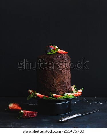 Rustic chocolate high cake with strawberry, dark background, selective focus