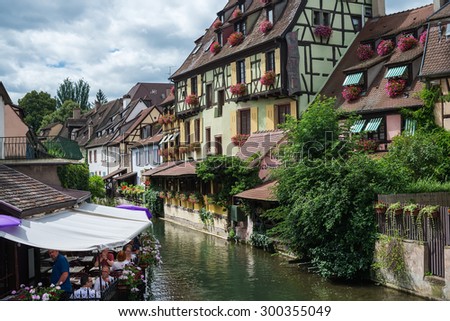 COLMAR, FRANCE - JUNE, 20: Colorful traditional french houses and a small restaurant terrace on the side of river Lauch in Petite Venice, Colmar, France on June, 20, 2015