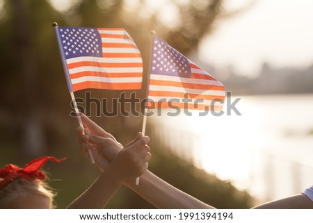 Patriotic holiday. Happy family, mother and daughter with American flag outdoors on sunset. USA celebrate independence day 4th of July. Stockfoto © 