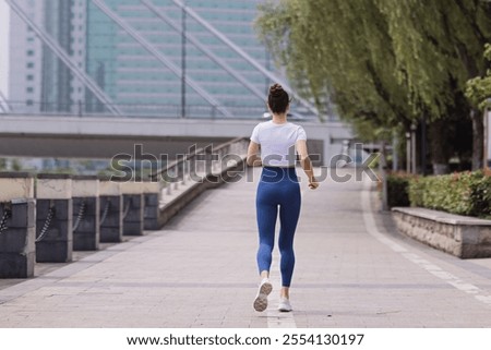 Similar – Image, Stock Photo Young brunette Woman running on asphalt road in summer park. Active sporty caucasian female has morning workout. Athletic person in sportswear exercises outdoor. Dressed leggings and sportive top