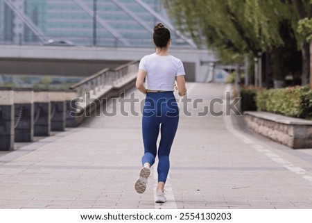 Similar – Image, Stock Photo Young brunette Woman running on asphalt road in summer park. Active sporty caucasian female has morning workout. Athletic person in sportswear exercises outdoor. Dressed leggings and sportive top