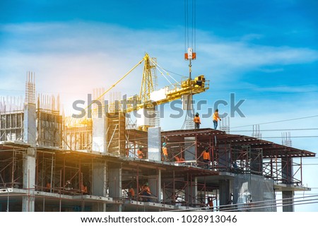 Foto Bild Hohes Gebäude in Baugerüst gegen blauen Himmel, Bauarbeiten auf der Baustelle, Restaurierung neuer Komplex