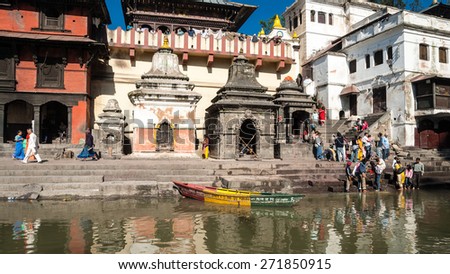 PASHUPATINATH TEMPLE, KATHMANDU, NEPAL-OCTOBER 18, 2008: Nepali  people, young and old, arrive to take a bath or wash cloths in Bagmati river. It is considered a holy river by Hindus and Budhists.
