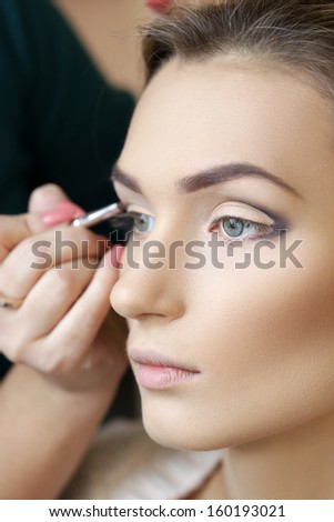 applying shades on eyes by make-up artist, backstage
