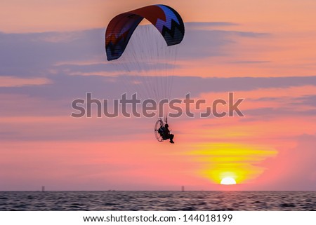 Man with para-glider flies in the sunset beach at Bangsaen,Thailand