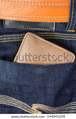 Brown wallet in blue jeans and brown leather belt