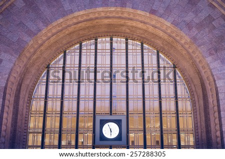 Wide window and clock at facade of Helsinki main railway station in Finland in evening lightning - architecture background