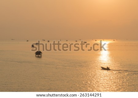 Silhouette fishing boat out to fish sunrise at Bangtaboon Bay, Thailand.