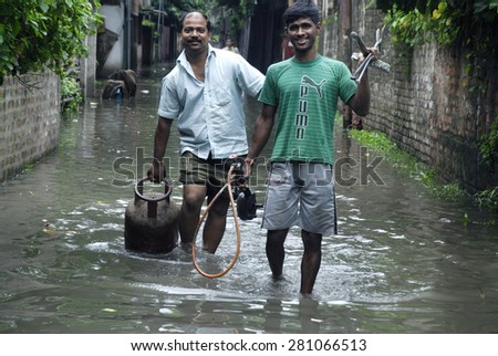 Calcutta, India - August 19, 2013: People carry gas cylinder and other house hold things in safer place as city flooded due to monsoon rain on August 19, 2013 in Calcutta, India.