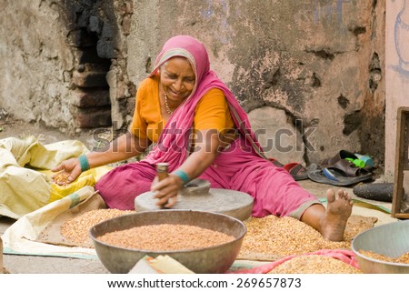 MAHARASHTRA, INDIA - April 23, 2011: lady with stone hand mill grinding wheat Grains rural village Salunkwadi Ambajogai Beed Maharashtra India asia