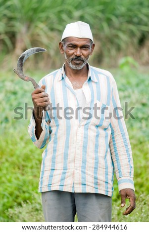 Farmer close-up with holding sickle rural village, Salunkwadi, Ambajogai, Beed, Maharashtra, India.