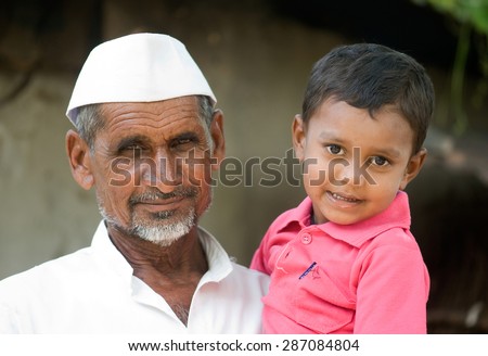 MAHARASHTRA, INDIA SEPTEMBER 22, 2011: Indian rural old man with grand son, SEPTEMBER 22, 2011, rural village, Salunkwadi, Ambajogai, Beed, Maharashtra, India