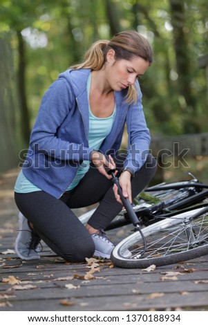 Similar – Image, Stock Photo Woman inflating bicycle tire in workshop