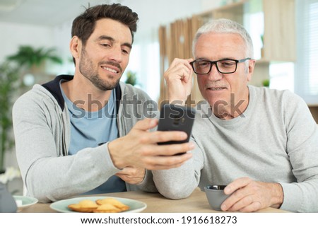 Similar – Image, Stock Photo Father and son using digital tablet together at night in bed