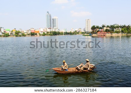 Hanoi, Vietnam - May 20 : Vietnamese men in a boat clean West lake on May 20, 2015 in Hanoi, Vietnam