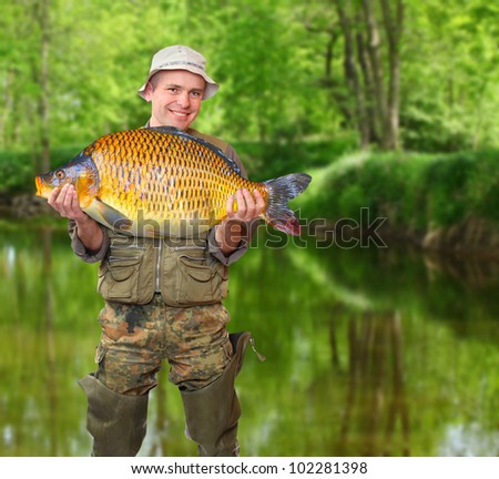 The fisherman with his big carp at a beautiful river.