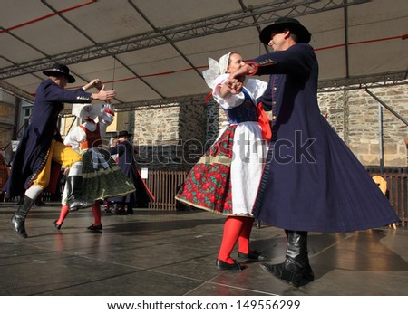 DOMAZLICE CZECH REPUBLIC - AUGUST 10: The Folklore Ensemble Usmev (Smile) dressed in traditional Czech (Pilsen) garb dancing and singing on The Chodske slavnosti medieval market on August 10, 2013.