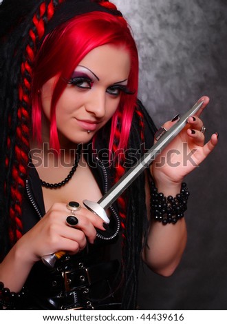 Portrait of bizarre red hair Gothic Girl with dagger. Low key studio shot. Great for calendar.