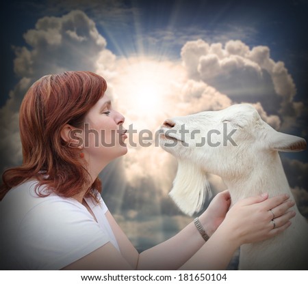 Funny picture of a young farmer woman with his goat.